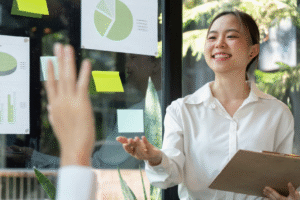 Mulher com óculos escrevendo em post-it coloridos sobre vidro — brainstorming visual em ambiente profissional.